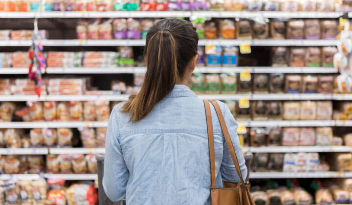 Woman with eating disorder chooses food in supermarket