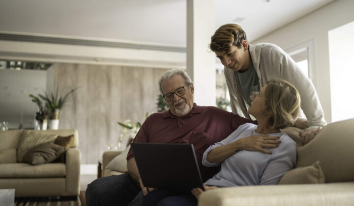 Teenager boy using notebook with grandparents