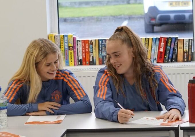Two young Manchester United players in a mental health workshop discussing the materials