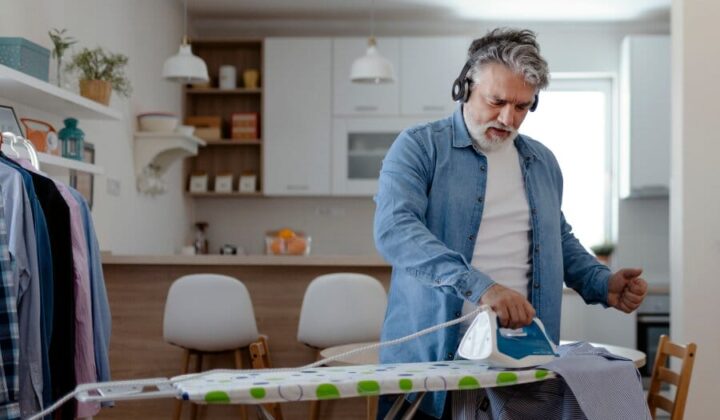 Man ironing shirts