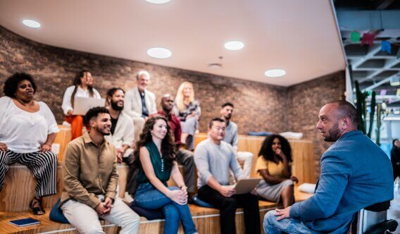 Group of people listening to speaker at the front of the room