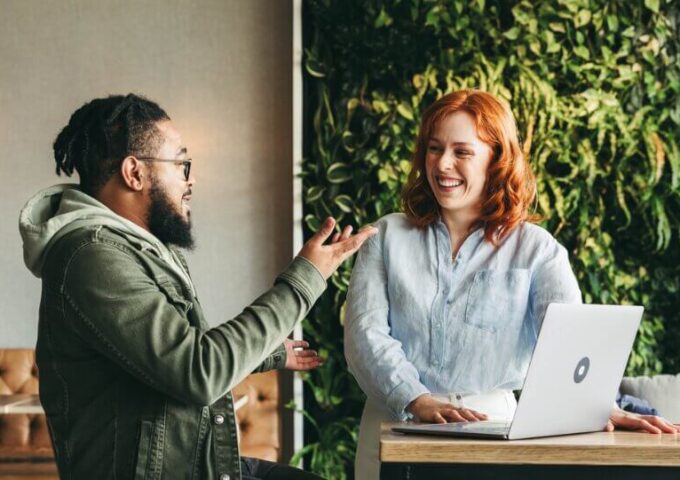 Two people talking and smiling at work