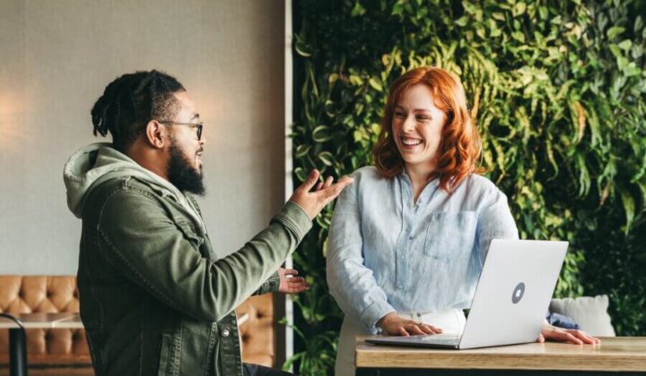 Two people talking and smiling at work