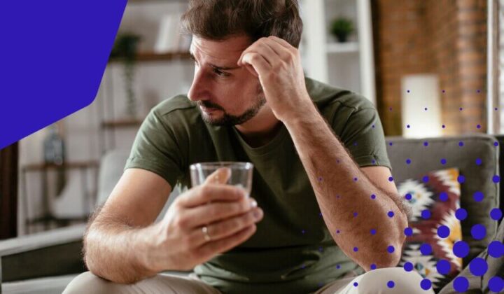 Man looking away from a glass in his hand