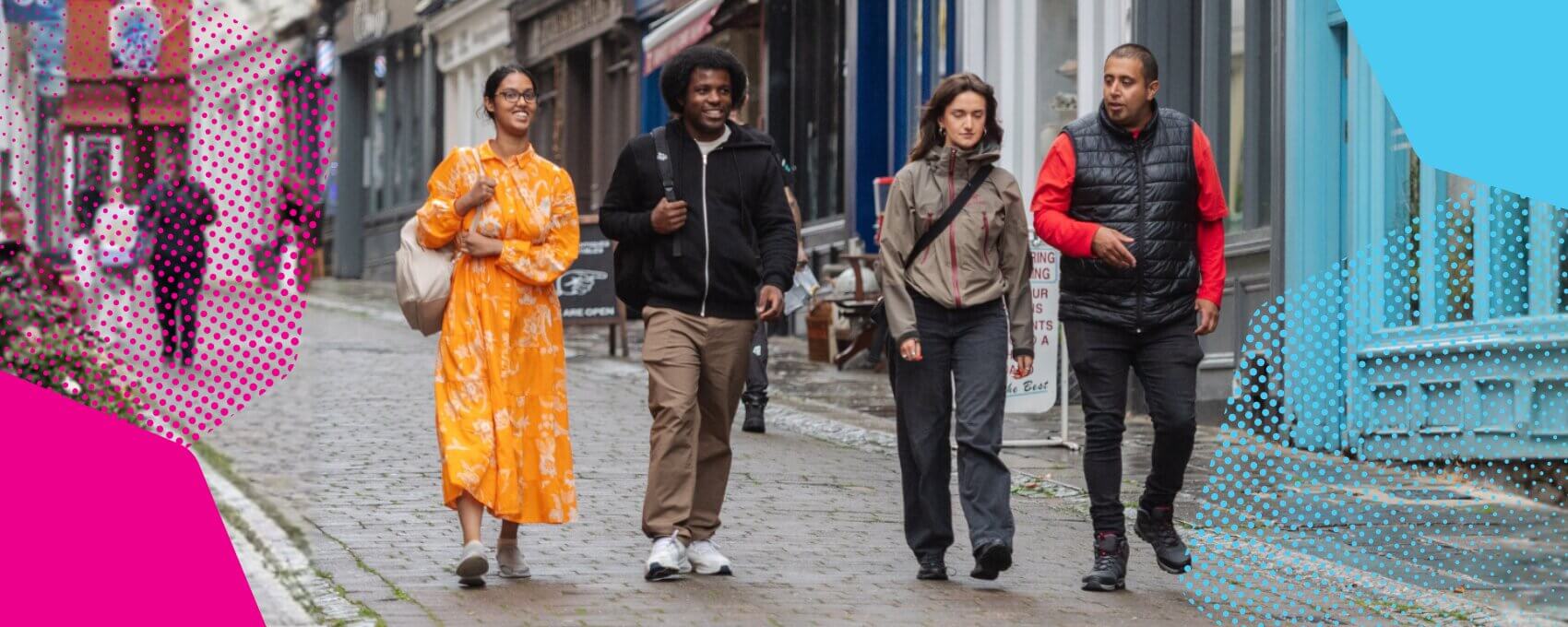 A group of people walking down the high street chatting