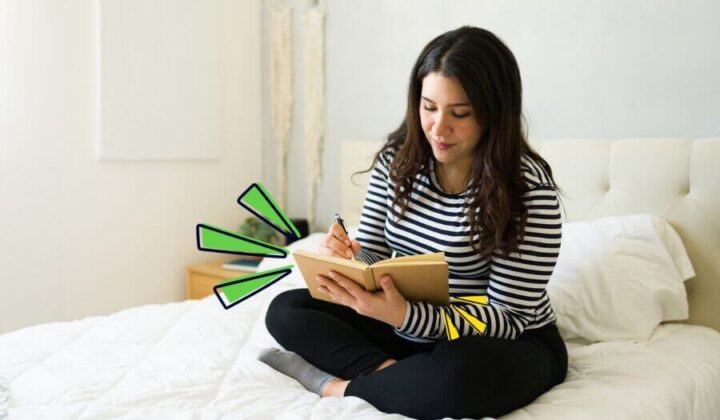 Lady sitting on her bed writing a journal