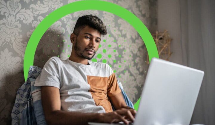 Man sitting in bed working on his laptop