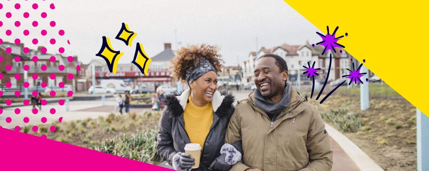A smiling couple laughing as they walk along the high street